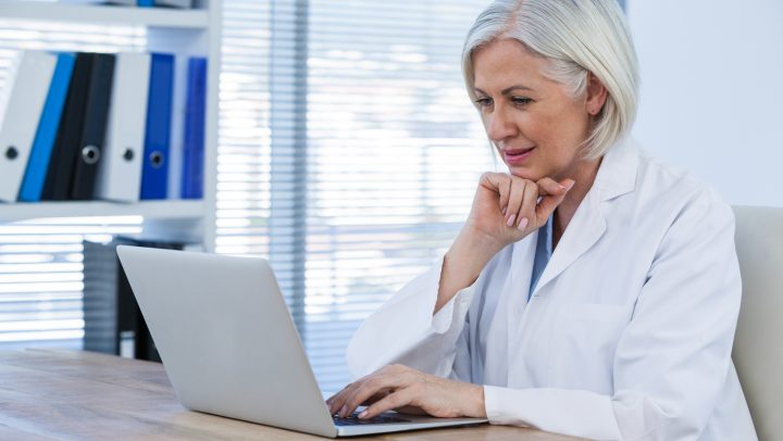 Thoughtful female doctor working on her laptop in clinic